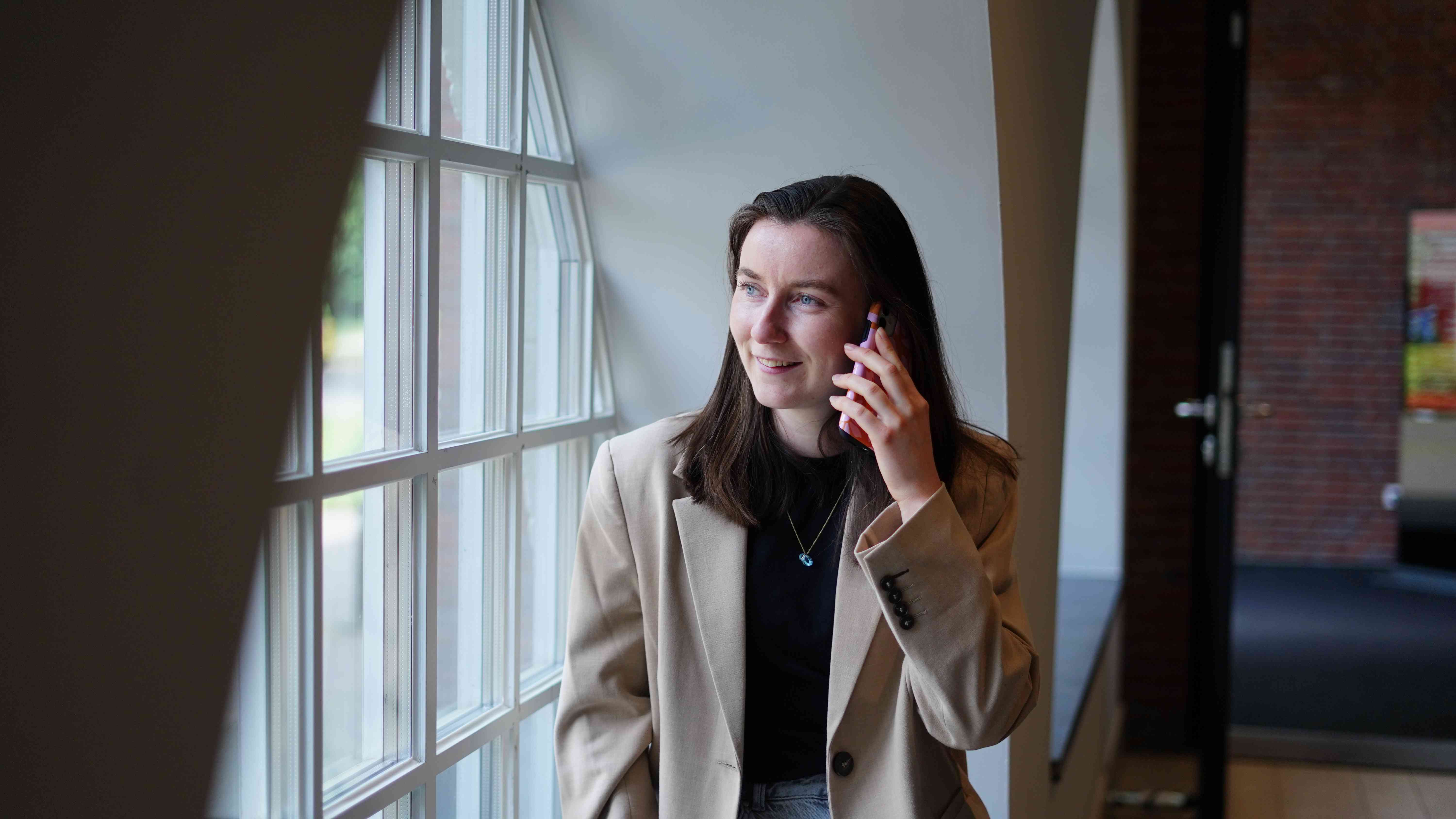 Een medewerker is aan het bellen en kijkt naar buiten
